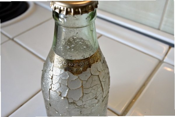 Vintage glass soda bottle with peeling white paint and crown cap