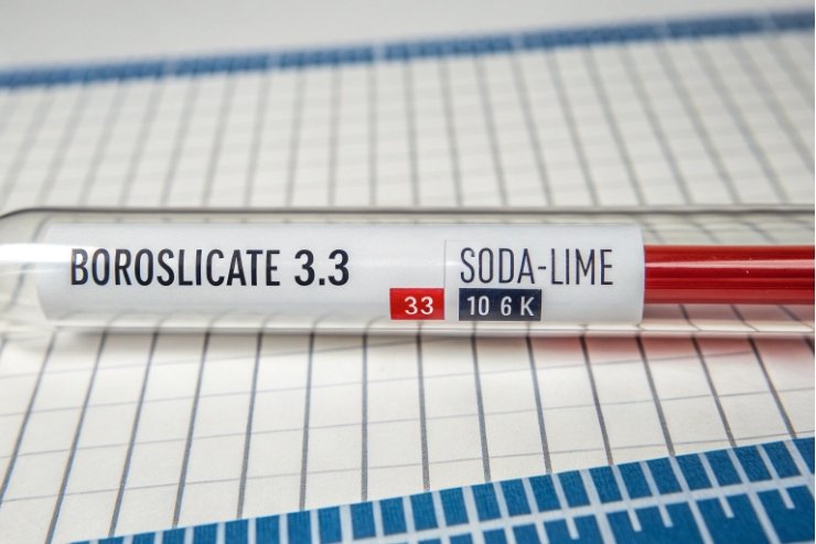 Glass sample tube labeled borosilicate 3.3 versus soda-lime for comparison