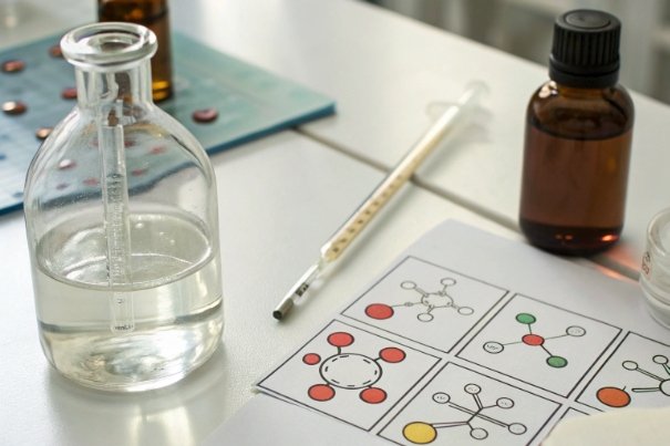 Formulation Lab Test Glass flask with pipette and molecule diagrams for formulation testing in laboratory