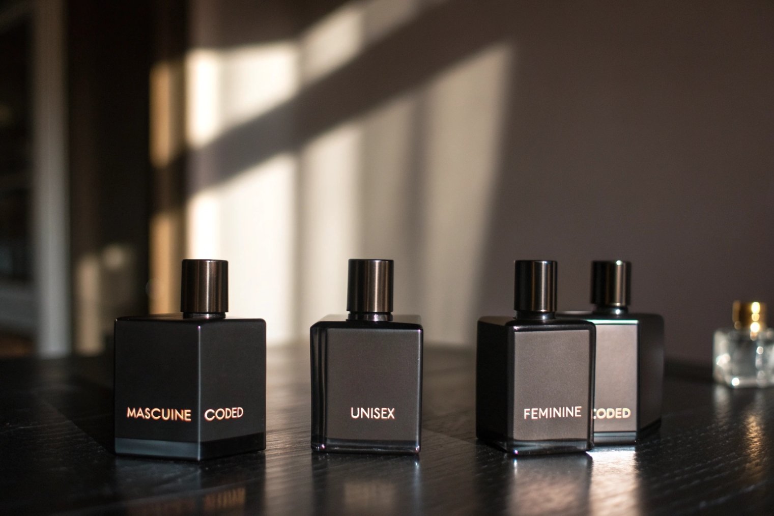 Matte black square perfume bottles for masculine unisex and feminine fragrances.