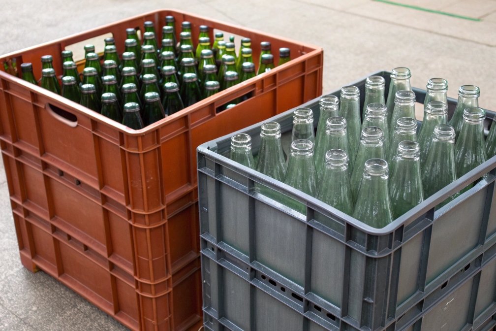 Crates with filled glass bottles stacked together