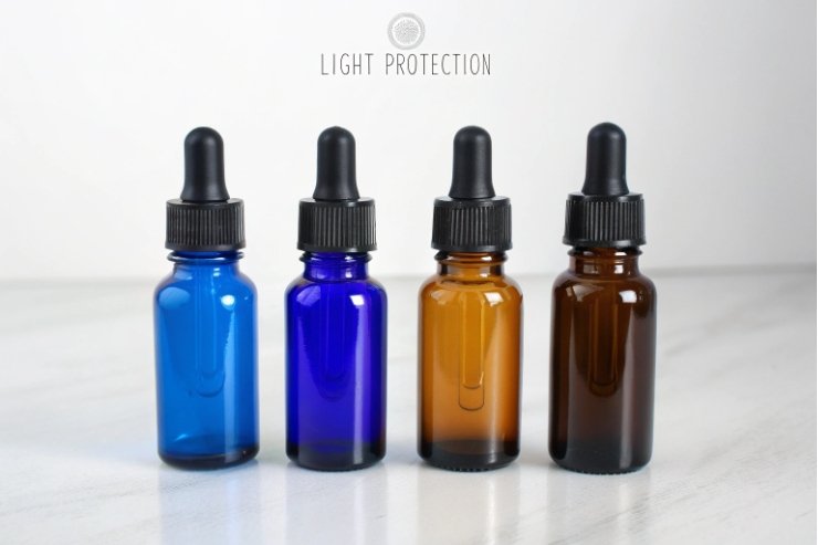 Blue and amber glass dropper bottles showing light protection on white background