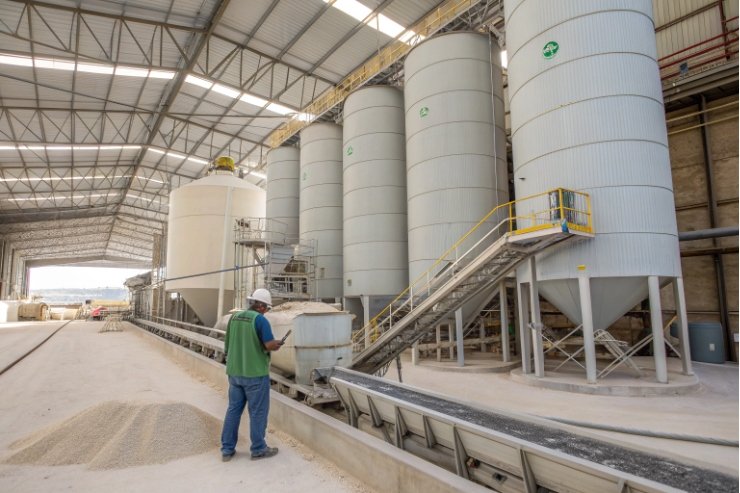 Glass batch material silos with worker monitoring conveyor in production plant