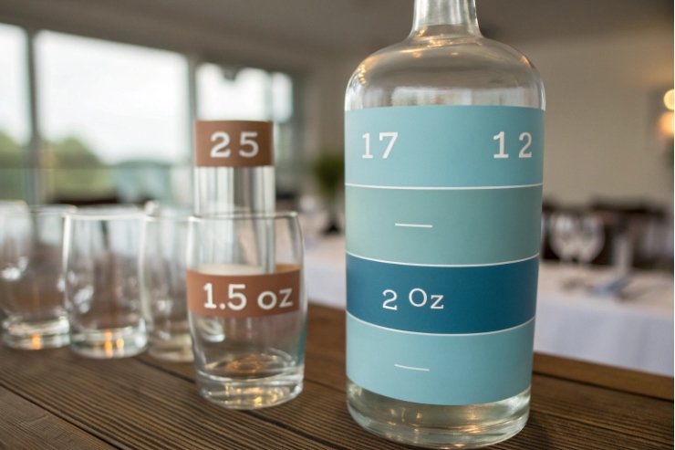 Spirits measuring glass bottle and tumblers with printed ounce volume markings