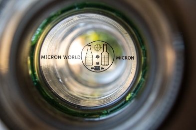 Bottom view inside glass bottle showing Micron World logo and embossed base ring