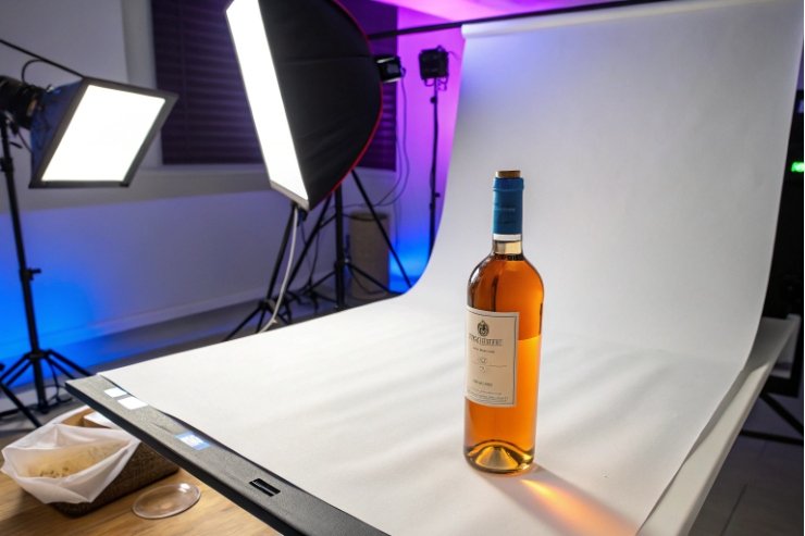 Studio product photography setup shooting amber wine bottle on white backdrop
