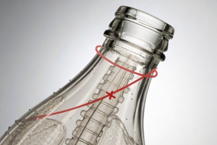 Clear glass bottle neck with red reject mark highlighting finish defect and stress area