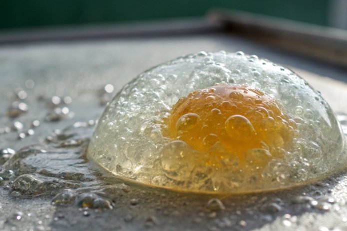 Domed blister bubble on wet surface illustrating glass defect or contamination reaction
