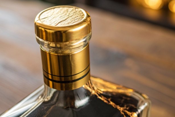 Close-up of gold bottle cap and neck on premium spirits bottle