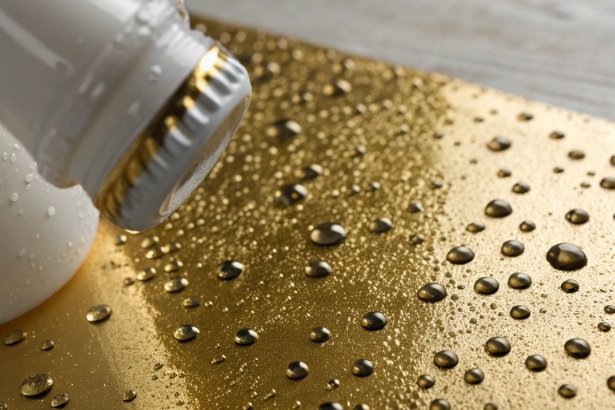 Bottle cap on wet golden surface with water droplets highlighting coating and anti-rust finish