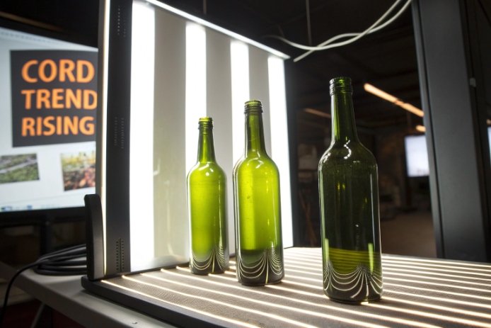 Light-panel inspection of green wine bottles to detect cord and quality defects.