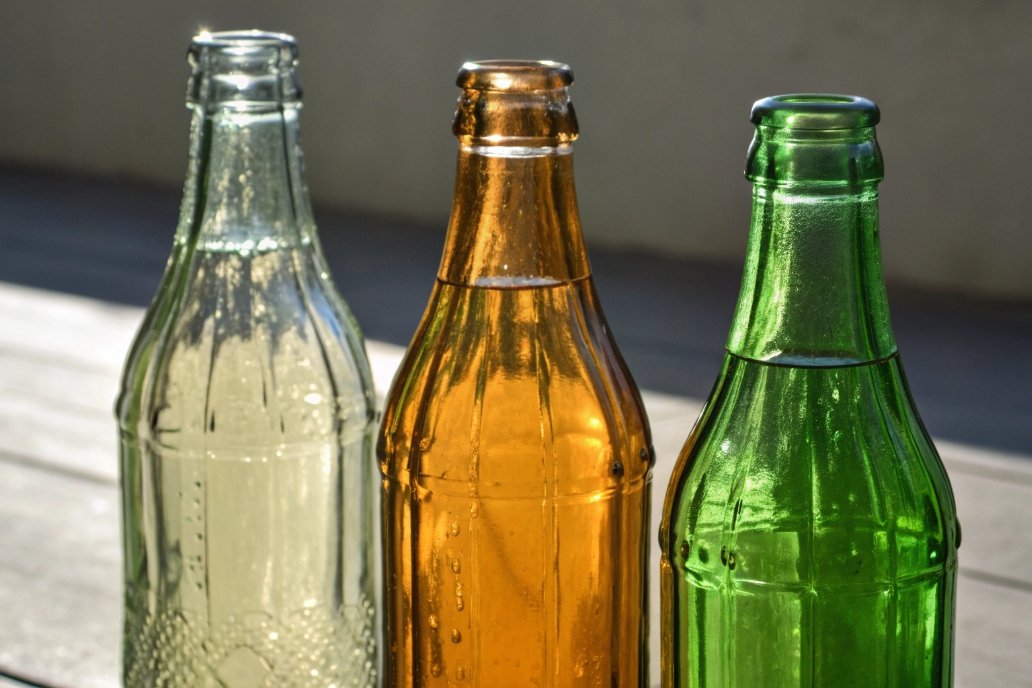 Green, amber, and clear glass bottles in a row