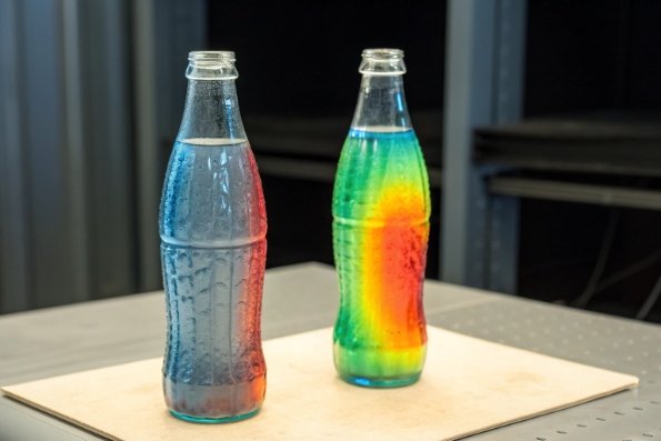 Two glass bottles showing thermal stress patterns and heat distribution test results
