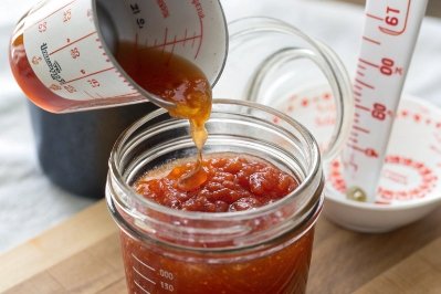 Sealed jam jars cooling on folded towel near window with safety notes about drafts