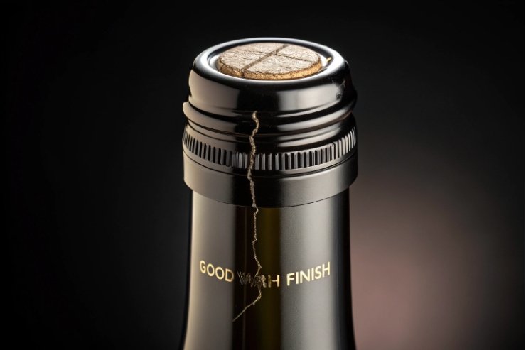 Close-up of wine bottle neck finish with capsule and cork for seal inspection