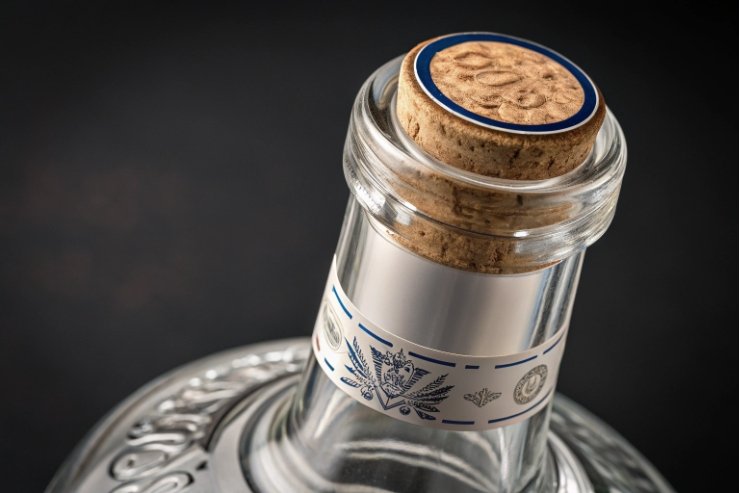 Close-up of cork stopper and tamper band on premium clear spirits bottle neck