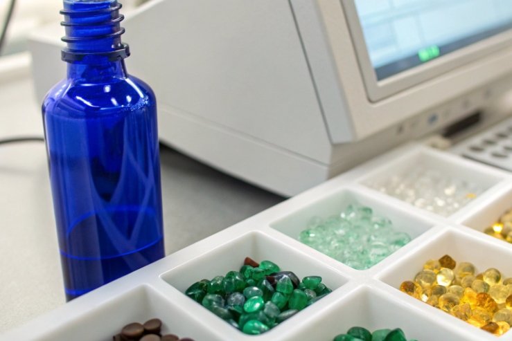 Blue glass bottle on lab bench with color samples for packaging testing