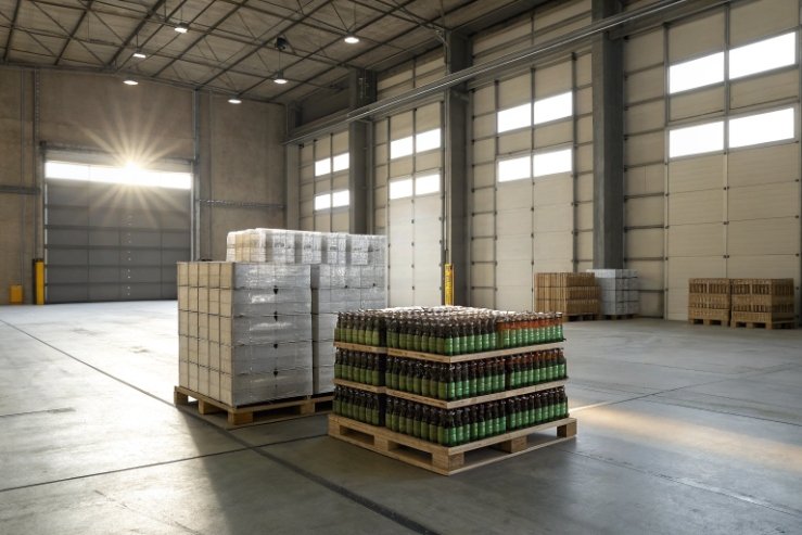 Pallets of green glass bottles stored in clean warehouse for bulk shipping