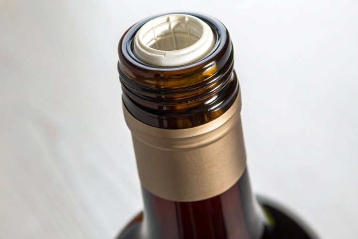 Close-up of bottle finish showing screw cap threads and inner seal liner