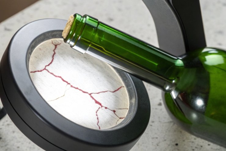 Green glass bottle neck with cork over magnifier, crack inspection concept