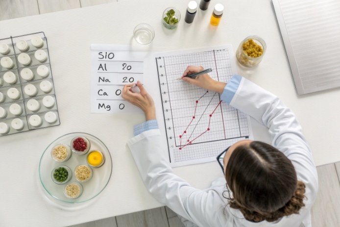 Lab technician plotting composition data for silica, alumina, soda, lime glass