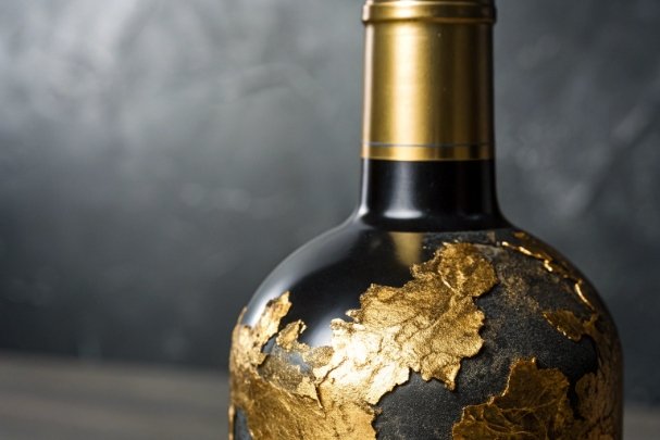 Black glass spirits bottle with gold leaf decoration for luxury packaging design