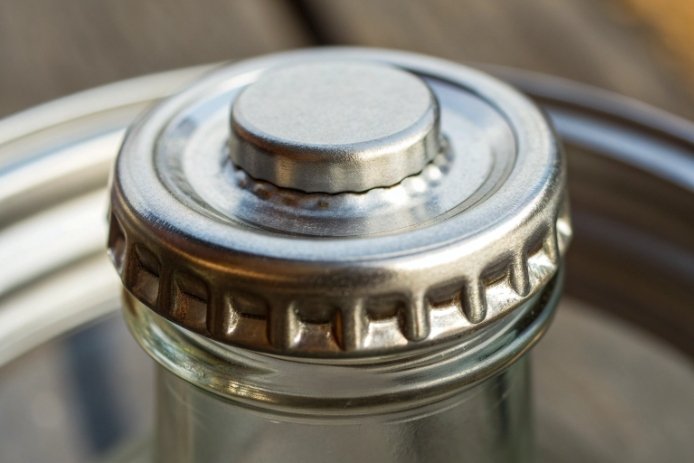 Macro detail of aluminum ROPP cap threading for tamper-proof spirit bottle sealing