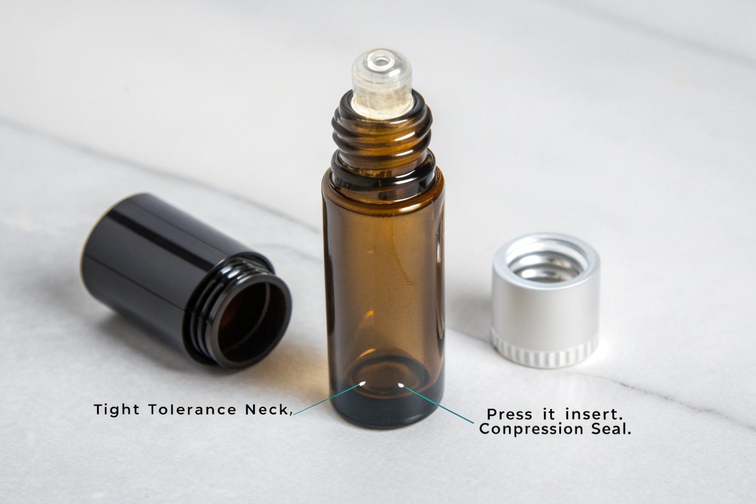 Disassembled amber glass roller bottle with clear insert and two different caps, annotated tight-tolerance neck and compression seal