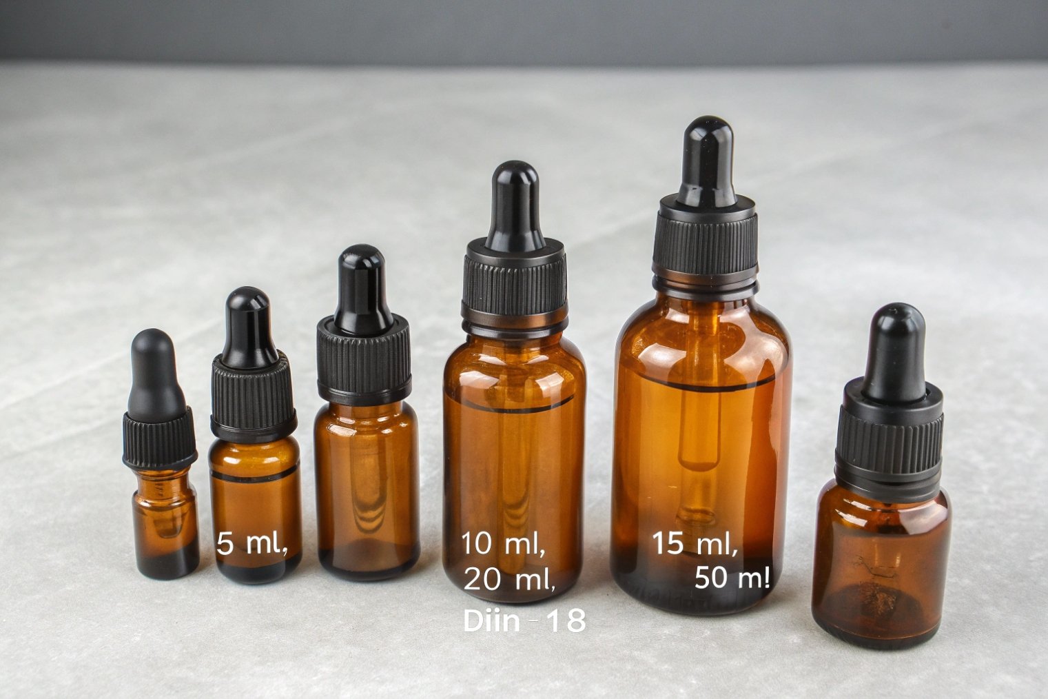 Amber glass dropper bottles arranged by size from 5 ml to 50 ml.