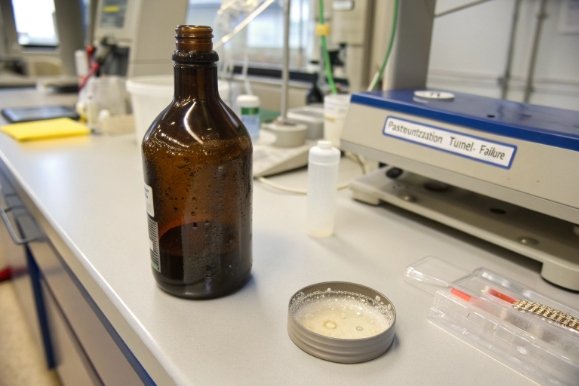 Laboratory setup with amber glass bottle sample for pasteurization tunnel failure investigation