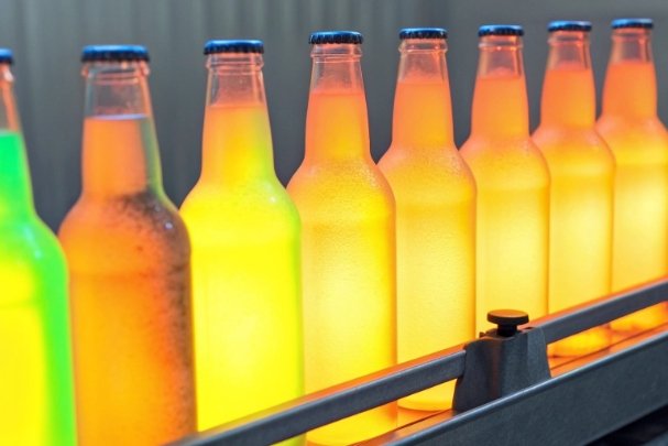 Glowing bottles on conveyor showing temperature gradient during annealing and heat treatment