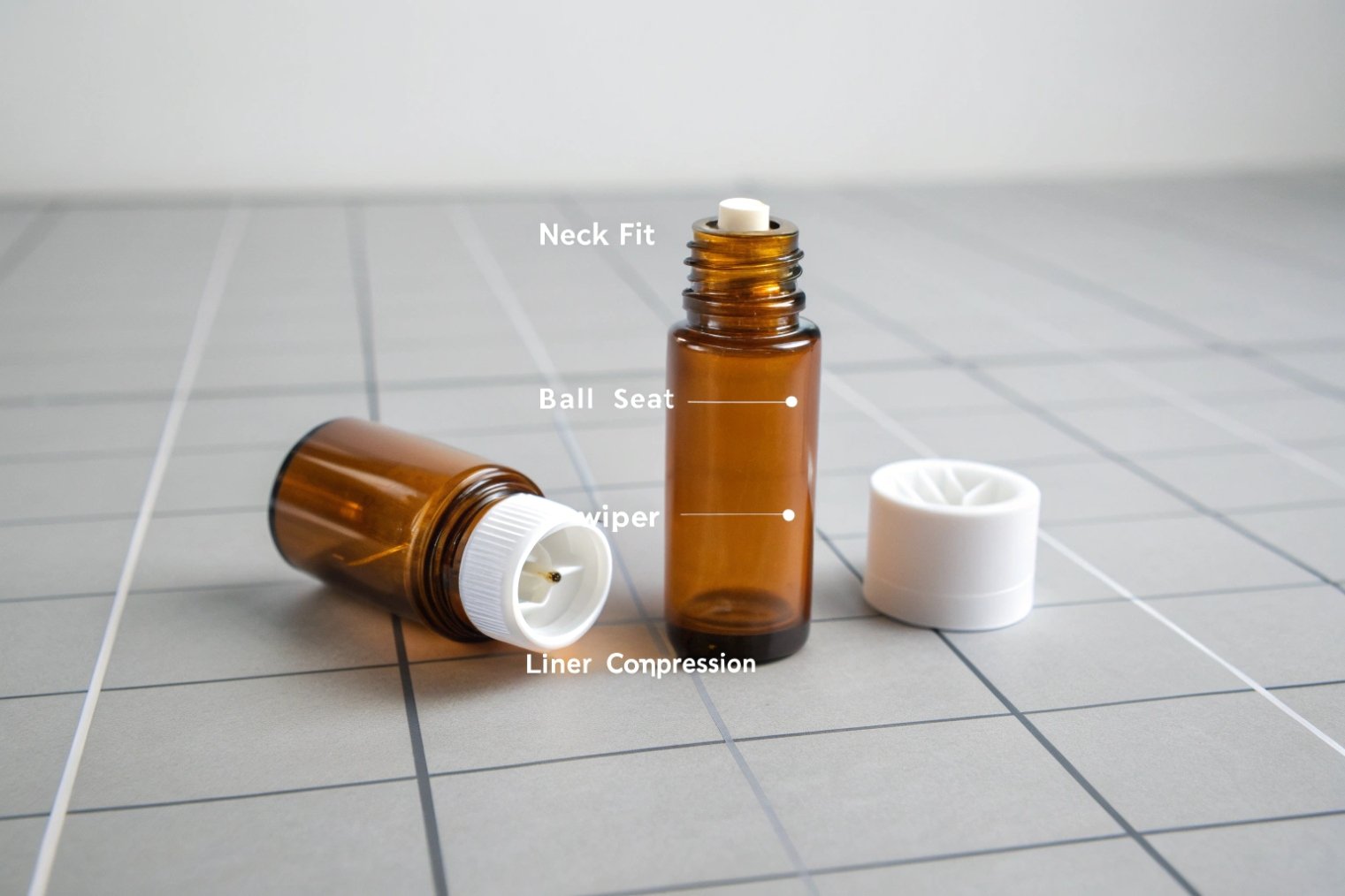 Amber roll on bottle components showing neck fit ball seat wiper liner.