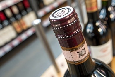 Close-up of tamper-evident screw cap with QR label on wine bottle