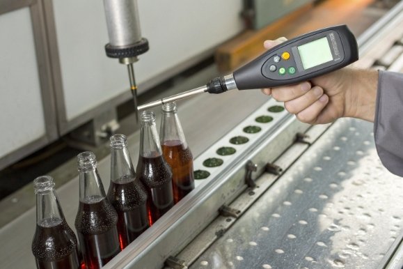 Inline fill level inspection of beverage bottles using digital sensor on bottling conveyor line