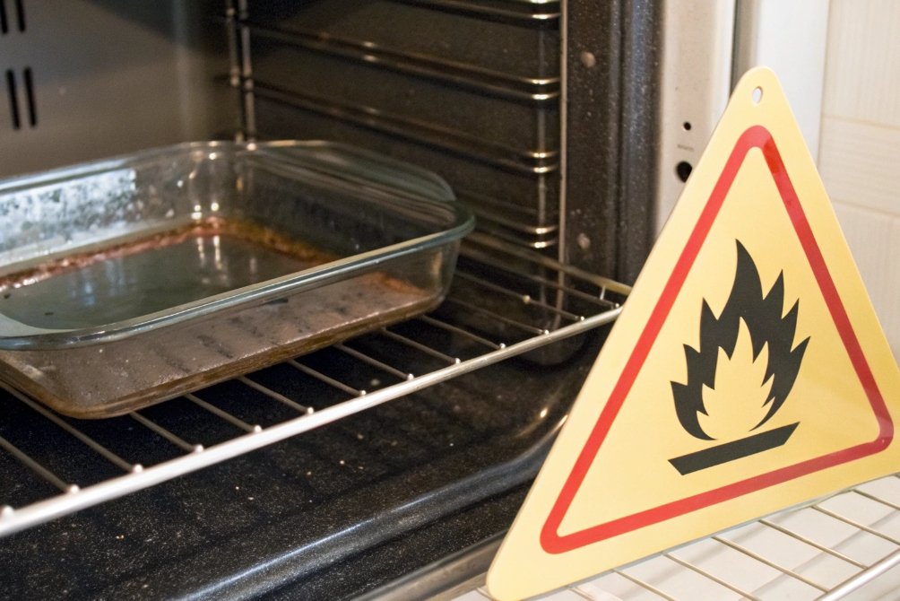 Empty glass baking dish with warning sign