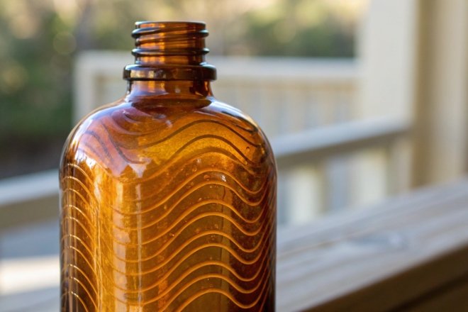 Amber glass bottle with wavy texture pattern highlighting decorative pharmaceutical packaging design
