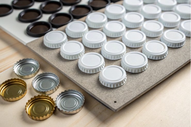 Selection of crown caps and screw caps arranged for glass beverage bottle closure testing.