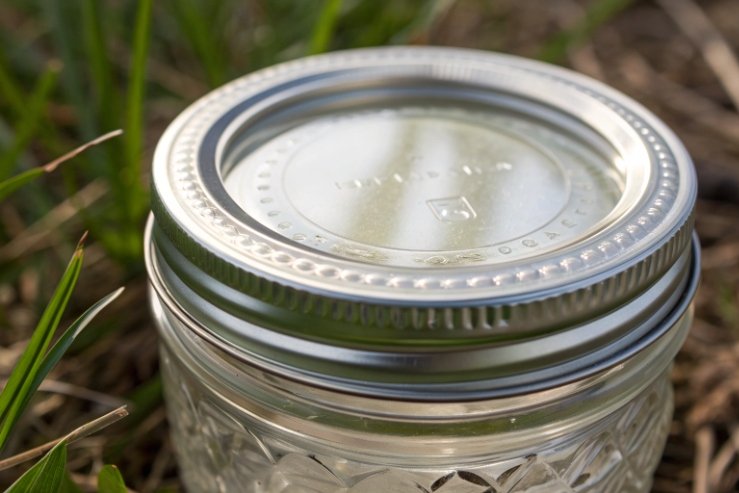 Close-up of mason jar metal lid showing tight seal outdoors