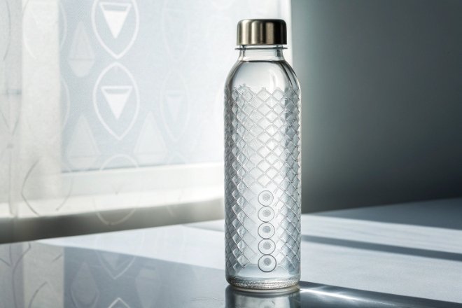 Textured clear glass water bottle with stainless cap in bright studio light