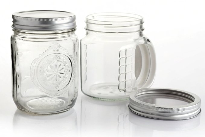 clear embossed mason jar and handled glass mug with metal lids on white