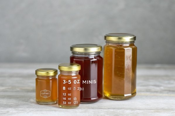 assorted mini and tall hexagon glass honey jars with gold lids