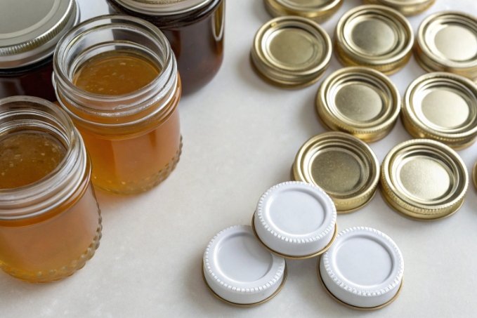 open glass honey jars with assorted metal and white twist lids