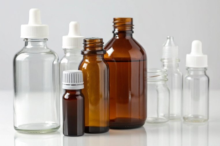 assorted clear and amber pharmaceutical glass dropper bottles with plastic caps