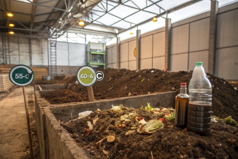 Industrial composting piles with organic waste, temperature signs and test bottles
