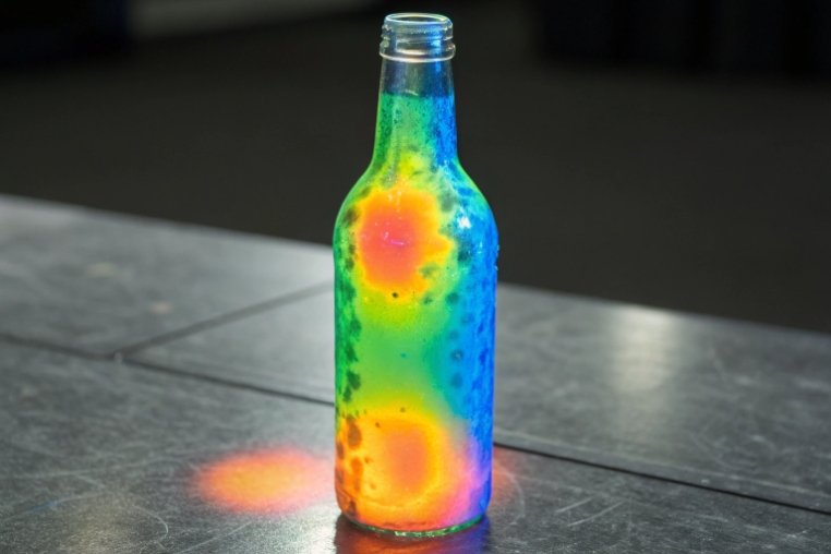 glass bottle covered in colorful stress pattern from impact analysis test
