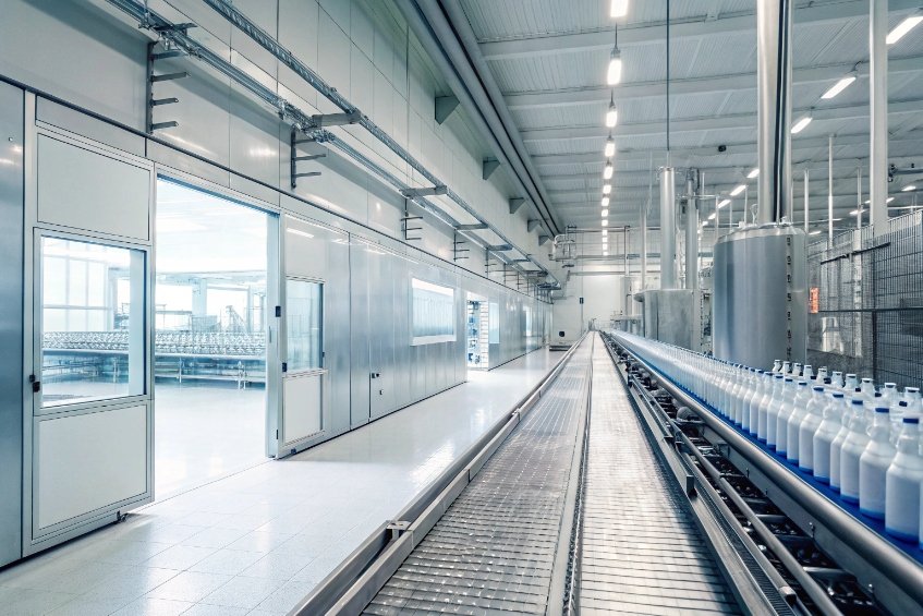 modern beverage bottling plant with conveyor line of white bottles in clean hall